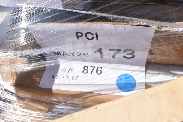 Plastic-wrapped auction items including a work table and air curtain, labeled as "MAY26-173," indicating 6 scratch and dent pieces.