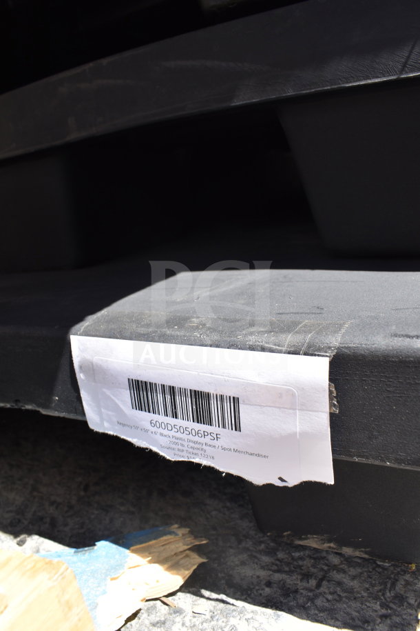 Black plastic display base labeled "Regency 55'' x 55'' Spot Merchandiser" with barcode 600D50506PSF. Scratch and dent condition.