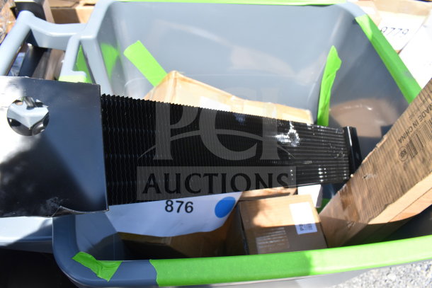 A bin containing new scratch and dent items, including boxes labeled "Made in China", and other miscellaneous items, lot number 876.