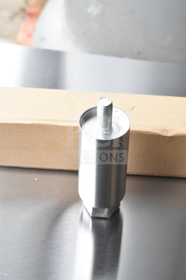 A metal component from the Avantco 177CO28M countertop convection oven on a reflective surface, with packaging in the background.