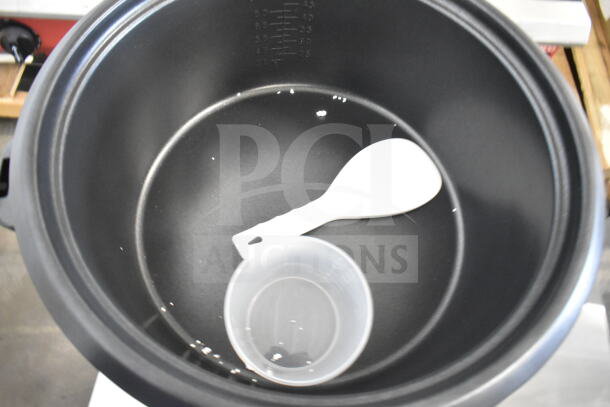 Brand new Avantco RCB90 rice cooker interior with measuring cup and spoon. Scratch and dent condition, 240V, 90-cup capacity.