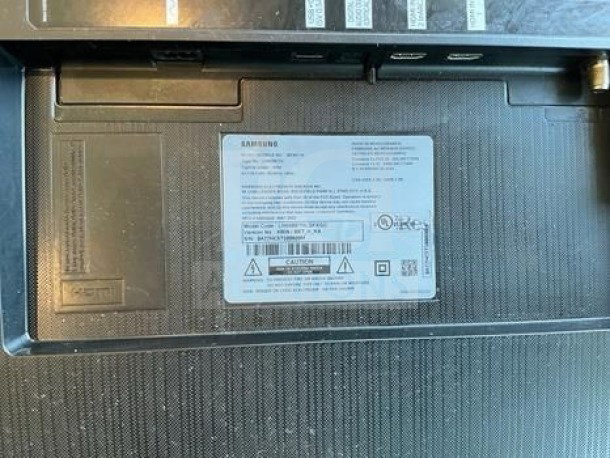Samsung 55" Q6F Series QLED 4K UHD Smart TV, model SAMSUNG-M-TV55-0760, showing back label with ports and specifications.