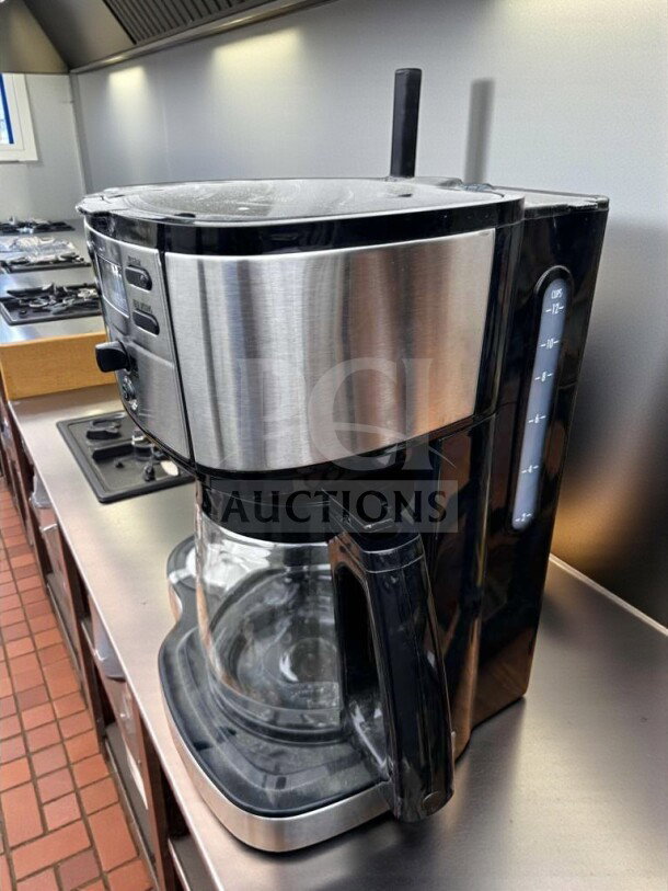 Brand new programmable 12-cup drip coffee machine with stainless steel and black finish, glass carafe, fully operational.