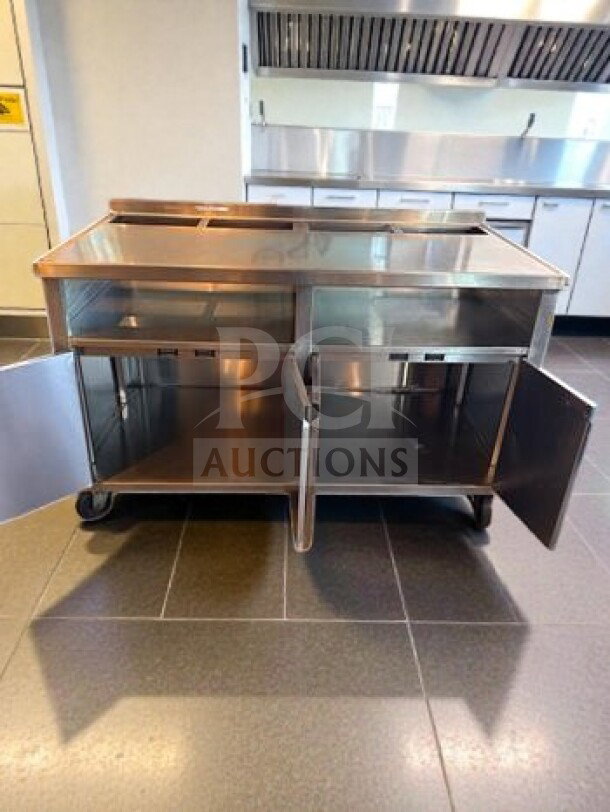 Stainless steel work table, 57"x31"x38", with under-cabinet storage. Mobile, excellent condition, ideal for commercial use.
