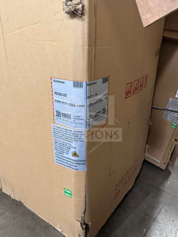Brand new KoolMore RD32C-SS refrigerated display case in original packaging; stainless steel; ETL listed; model details visible.