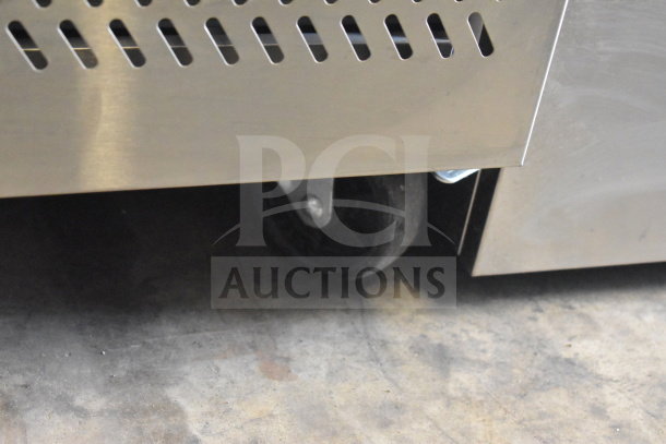 KoolMore KM-RPPS-2D59-GRT pizza prep station; steel frame, granite top, on commercial casters; 115V; visible wheel detail.