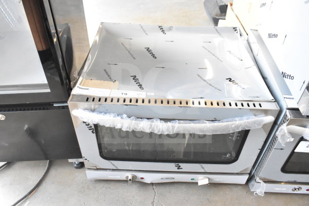 Brand new KoolMore KM-CTCO-15 countertop convection oven, 23 in., with 4 racks, 1600W, visible protective wrapping and markings.