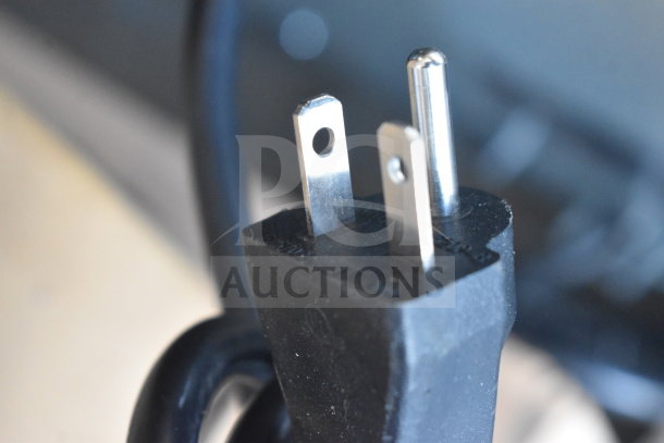 Close-up of a three-prong plug for the 2025 KoolMore KM-CTCO-23STI convection oven, emphasizing electrical compatibility.