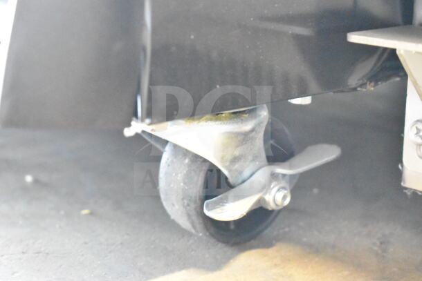 Caster wheel of KoolMore MDR-2GD-35C refrigerator, highlighting its mobility feature. Visible scratch on black panel.