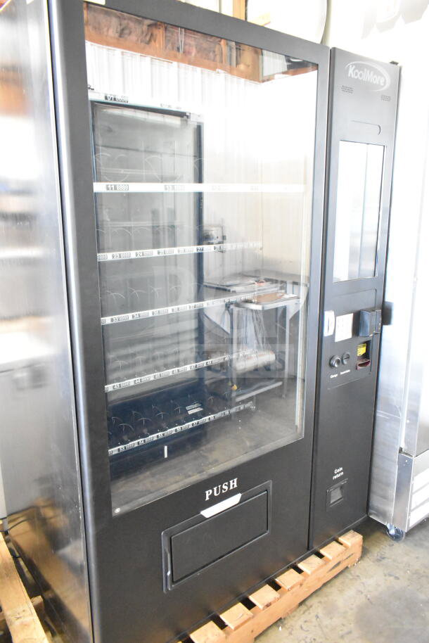 Brand new KoolMore commercial vending machine, minor scratches and dents visible, features multiple slots and keypad.
