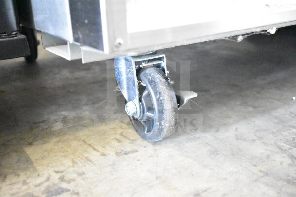 Commercial caster of 2024 KoolMore RIR-2D-SS refrigerator, shown with slight wear, indicating scratch and dent condition.