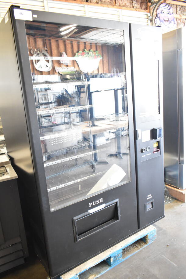 Brand new KoolMore commercial vending machine with minor scratches and dents, black exterior, visible glass front panel.