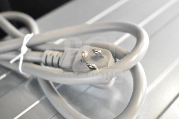 Close-up of a gray power cord and plug on a KoolMore Commercial Countertop Drawer Microwave Oven.