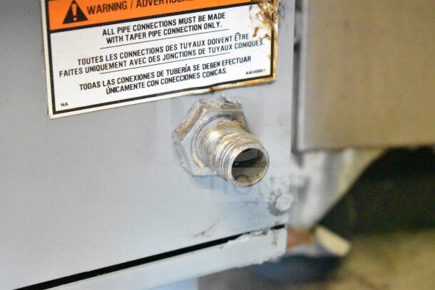 Pitco Frialator gas-powered deep fat fryer connection port, warning label on proper pipe connections, good condition.