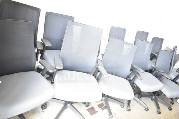 12 office chairs on casters, with mesh backs and cushioned seats, in good condition. Bid applies to all chairs.