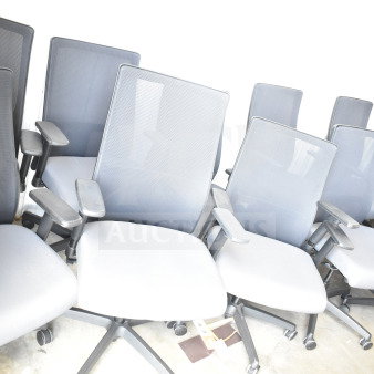 12 office chairs on casters, with mesh backs and cushioned seats, in good condition. Bid applies to all chairs.