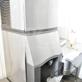 Manitowoc commercial ice head on hotel ice dispenser, stainless steel, used condition, large capacity, visible logo label.