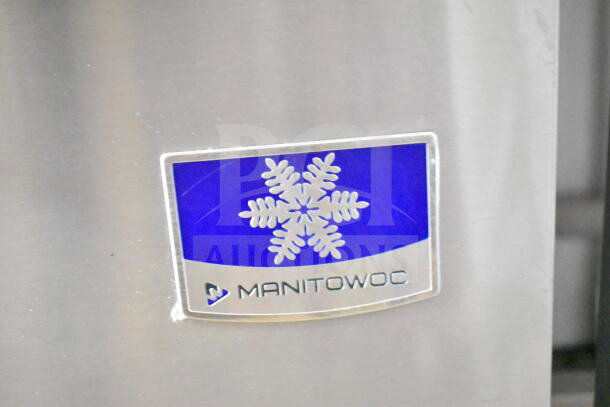 Manitowoc Commercial Ice Maker head on hotel dispenser, with logo showing a snowflake and "MANITOWOC" text, in good condition.