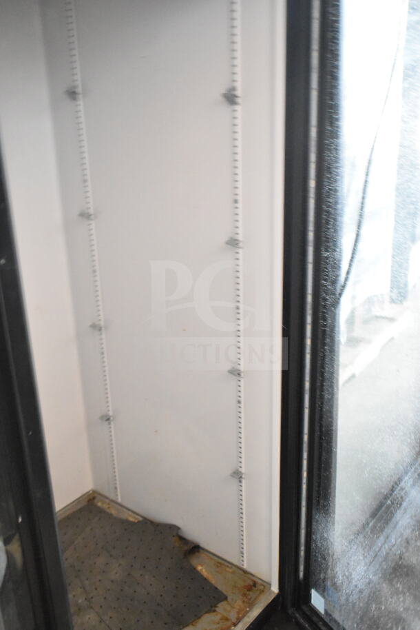 2019 True GDM-72-HC 3 Door Cooler, interior view. Visible shelving brackets, some wear on interior floor.
