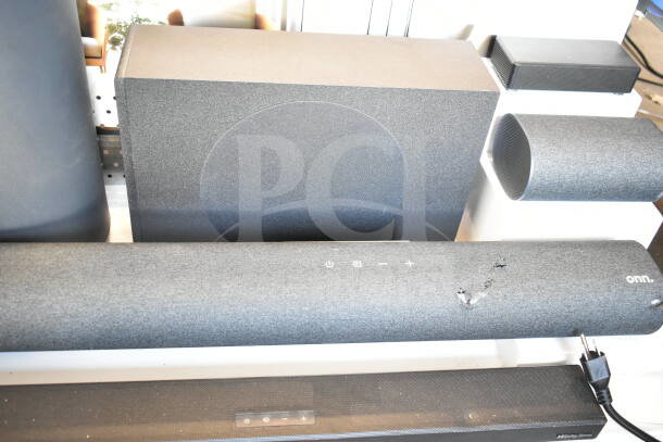 Store display featuring Onn sound bars and speakers. Includes visible controls and damage on sound bar surface. Used condition.