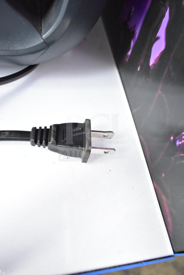 Electric plug of a display party speaker on a white surface with colorful background. Item in good condition.