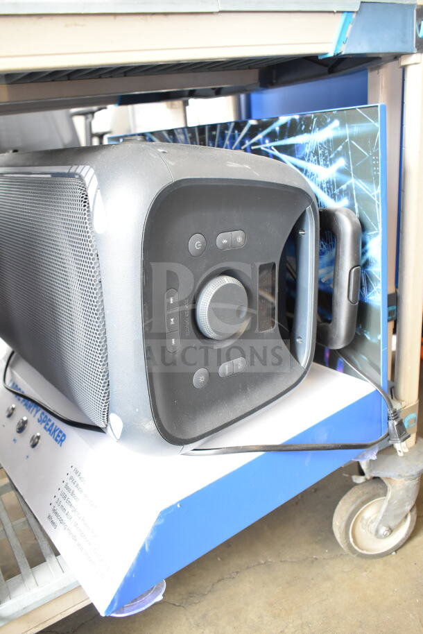 Large party speaker on a store display with control panel and power cord. Features USB connectivity, clear audio, and sturdy casing.