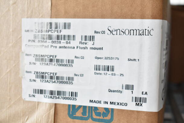 Cardboard box with Sensormatic ZBSMPCPEF label, showing part number, serial number, and "Made in Mexico" marking.