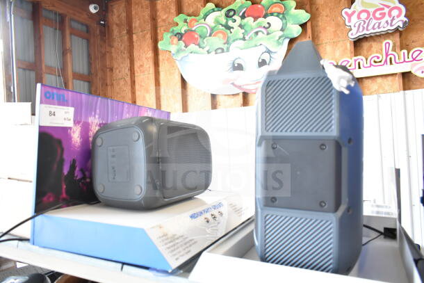 2-store display with Medium Party Speaker and Ion Speaker; on shelves with packaging visible; good condition.