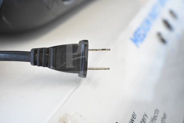 Power cord for a store display featuring a medium party speaker and Ion speaker, partially visible text.