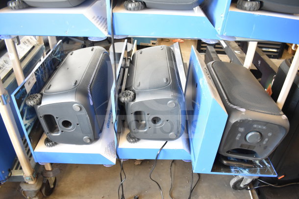 3 Onn large party speakers on store display, each with wheels for portability. New condition, suitable for events.
