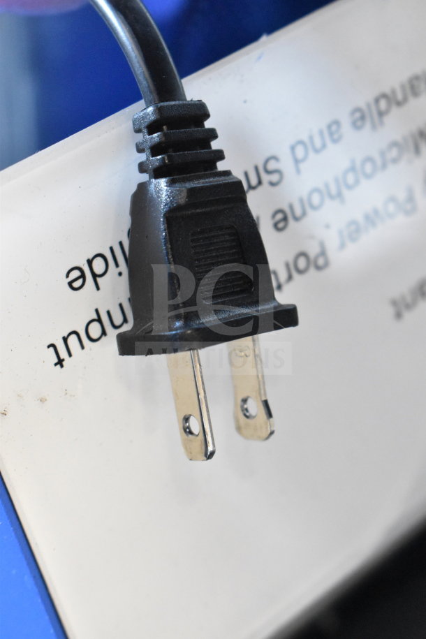 Power plug for Onn Large Party Speaker displayed on signage. Plug is standard two-prong type, indicating power connection.