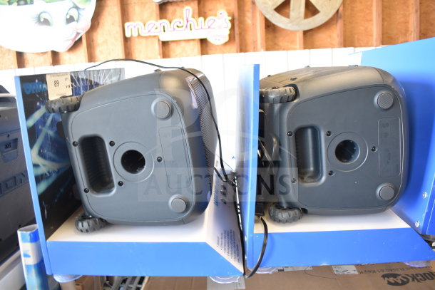 Onn large party speaker display with black casing, visible power cords, and blue shelving. New condition. Includes store signage.