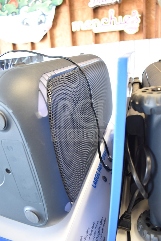 Store display with Onn large party speaker, showing black grille, power cord, and branding. Ideal for large gatherings.