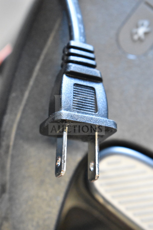 Close-up of a power cord plug associated with a JBL PartyBox310 speaker.