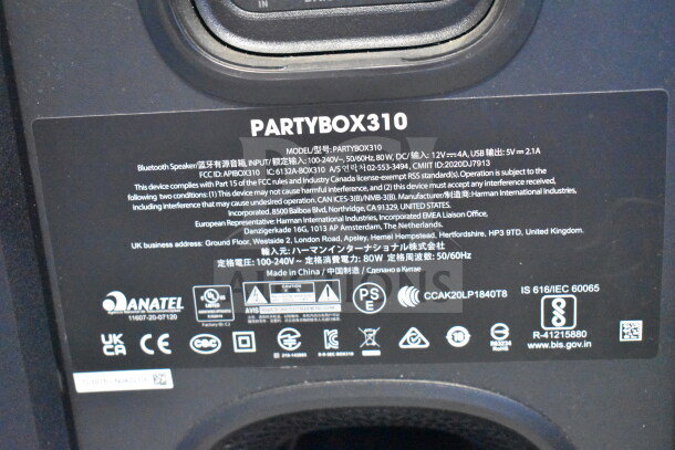 JBL PartyBox310 speaker label showing model details, compliance info, and safety certifications.