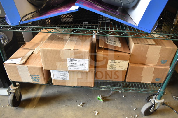 Eight Sensormatic items including ZBSMPCPEF, AMB-9010-IPS, DEAC STP-SD in boxes on shelf; sealed, labeled.
