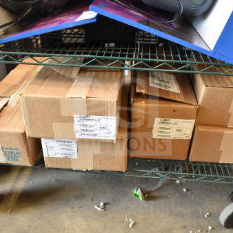 Eight Sensormatic items including ZBSMPCPEF, AMB-9010-IPS, DEAC STP-SD in boxes on shelf; sealed, labeled.