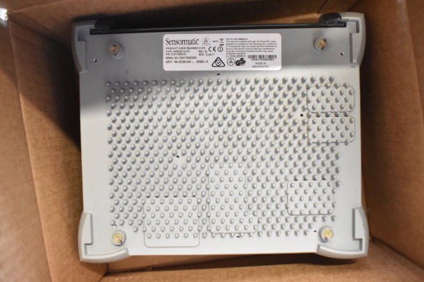 Sensormatic device with product label in a cardboard box, featuring model AMB-9010-IPS. Good condition, includes 8 items.