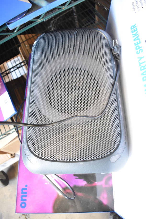 Onn Medium Party Speaker on store display, features power cord, metal grille, and branding. Good condition.