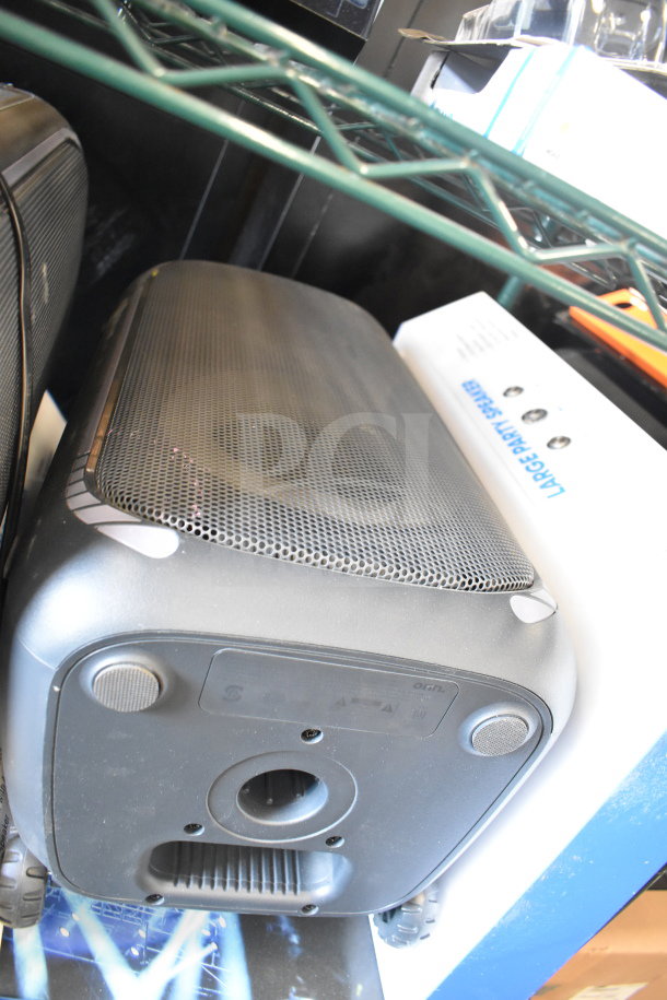 Onn large party speaker in store display, black with sturdy grille, visible control markings, new condition.