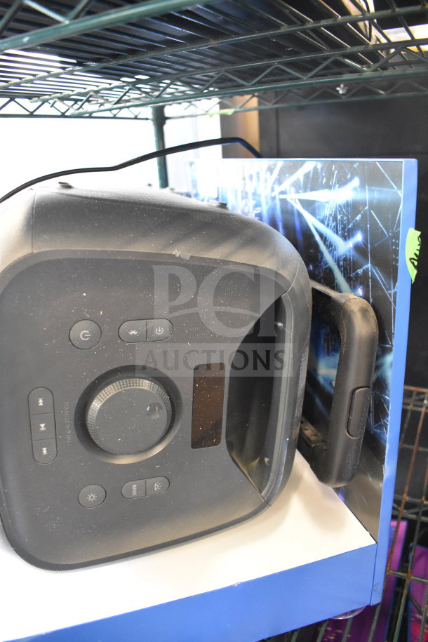 Onn large party speaker on display shelf, featuring control panel with buttons and knob. Good condition, slight dust visible.