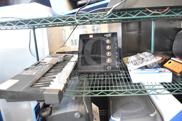 Four items on a shelf: electronic keyboard, Lego Smart Play device, packaged walkie talkies, and a box.