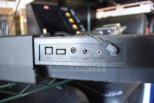Close-up of a keyboard's connection ports including MIDI, USB, audio input, mic, and phones output.
