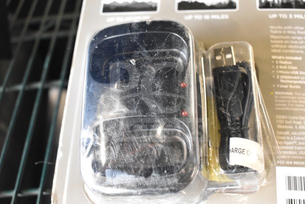 Packaging for walkie talkies with USB cable, mentions up to 3 miles range and includes user guide. Scratched plastic case.