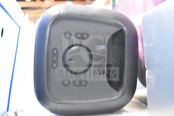 Onn Large Party Speaker on display, front control panel visible. Features volume dial, power, Bluetooth, and bass buttons.