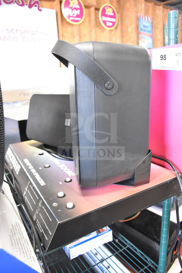 Store display featuring an Altec Lansing speaker on a metal shelf. The speaker is black with a textured handle.