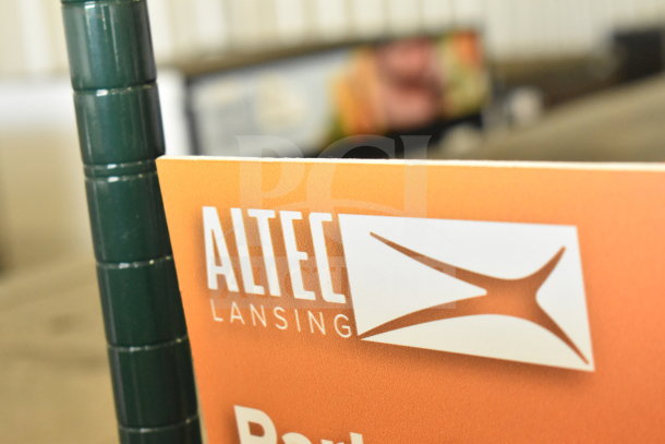 Altec Lansing store display, features brand logo on an orange sign. Condition appears well-maintained, ideal for promotions.