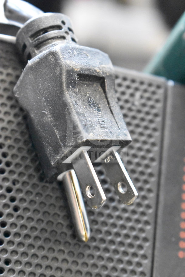 Altec Lansing speaker on store display, showing power plug detail, featuring a textured black grille.