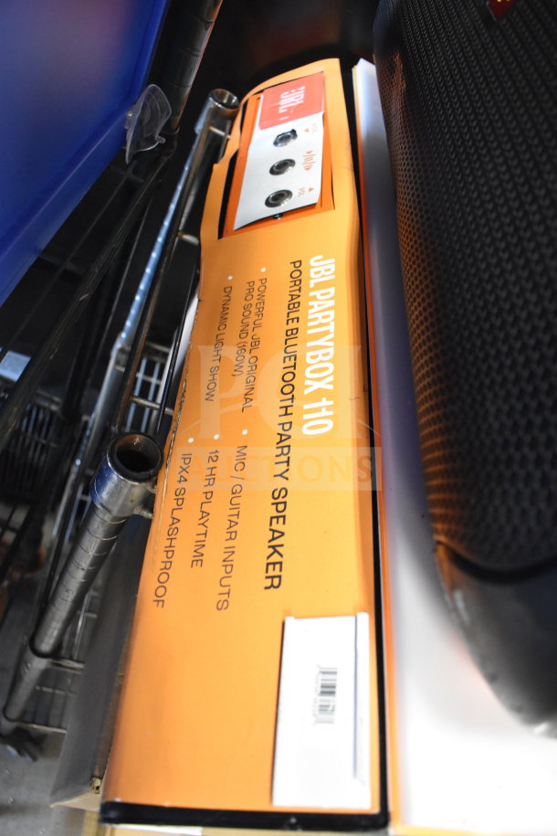 JBL PartyBox 110 speaker in original packaging, features Bluetooth, 12-hour playtime, mic/guitar inputs, and splashproof design.