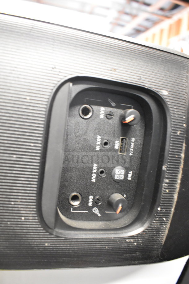 Close-up of a JBL speaker panel with various input and control knobs, showing gain, AUX in/out, USB port, and TWS connection.